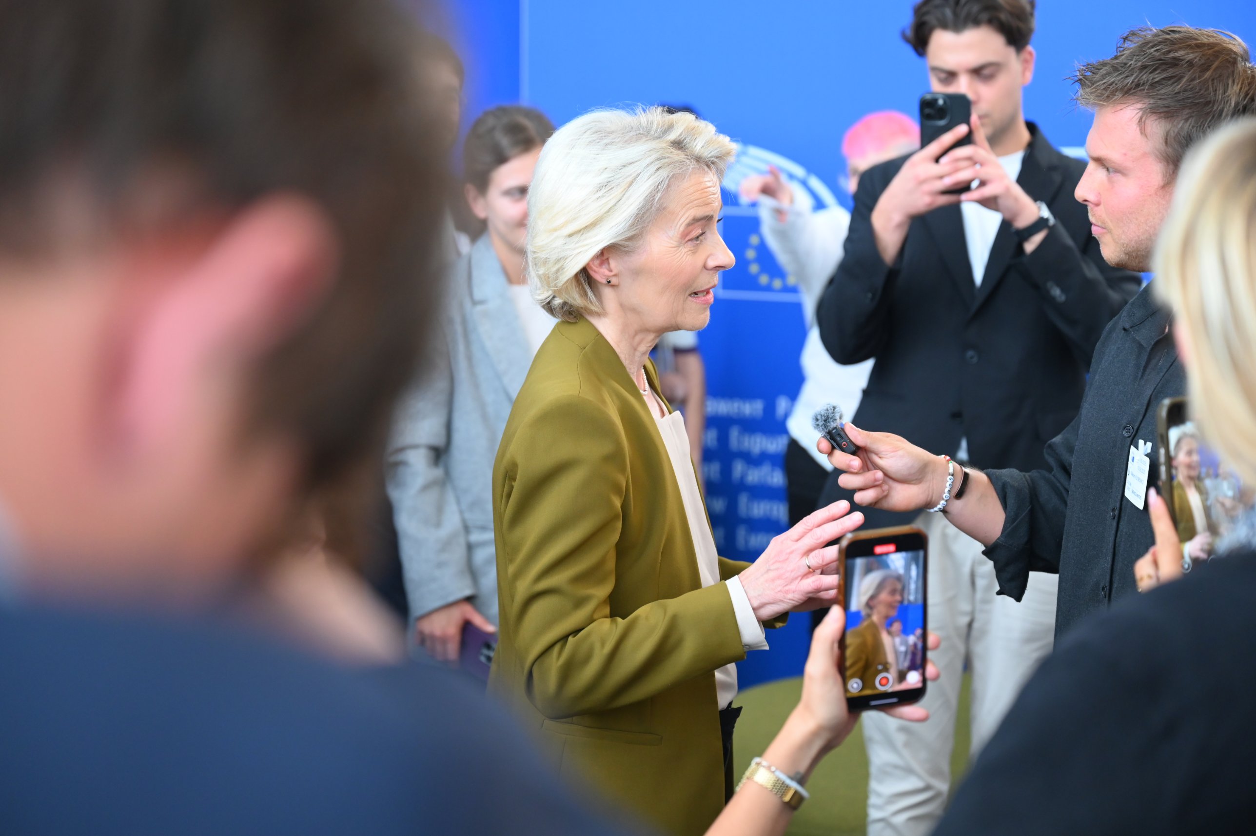 Ursula von der Leyen answering questions into a microphone at the European Parliament